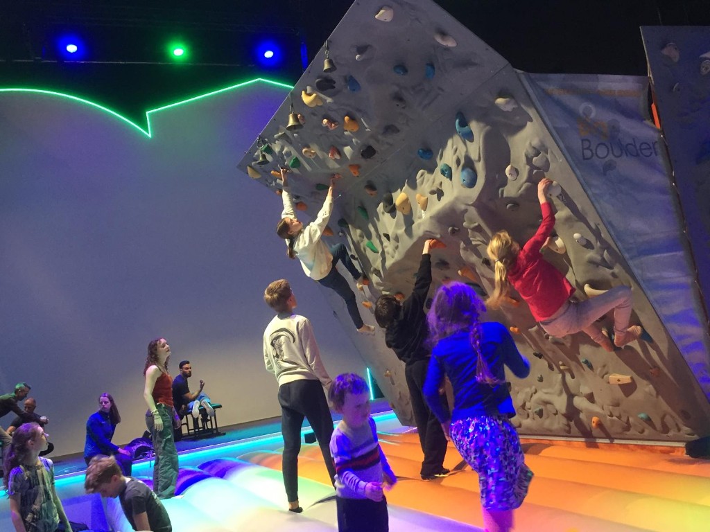 Kinderen klimmen op de boulderwand tijdens een evenement